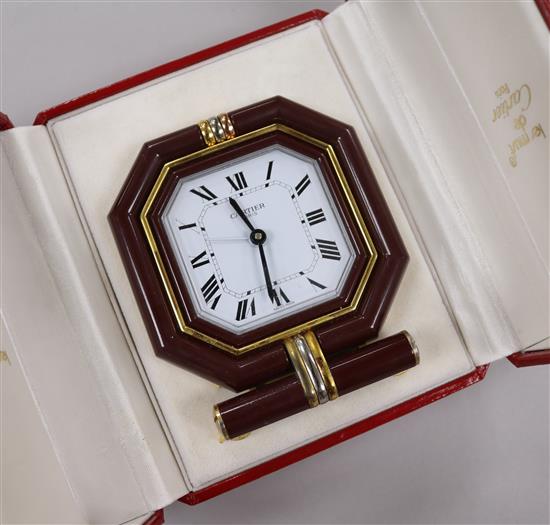 A Must de Cartier gilt metal and lacquer cased travelling quartz alarm clock, in fitted Must de Cartier case.